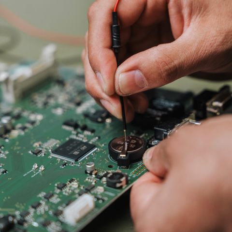 Platine Platine mit Händen, die ein Bauteil anbringen